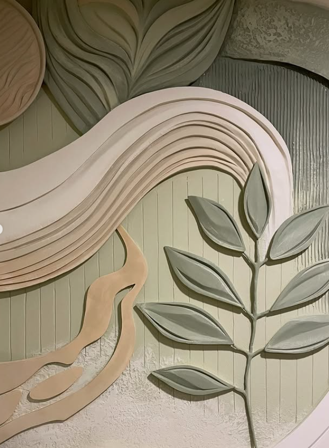 Abstract sculptural wall relief with organic leaf forms and flowing lines in soft green and neutral tones